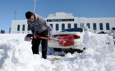 WSC student Allen Arauz scoops snow in the Rec Center parking Lot.