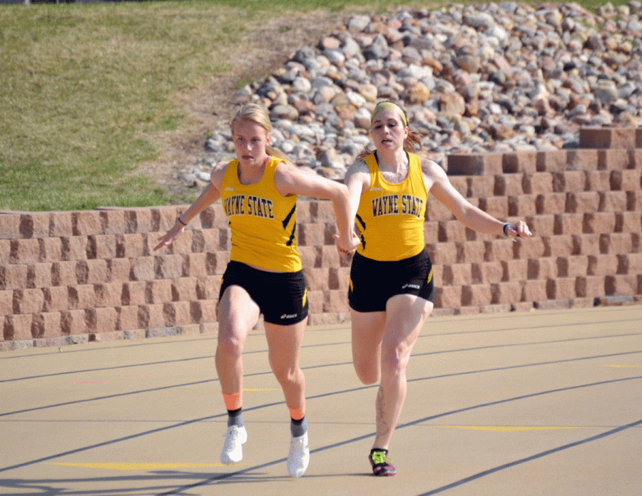 Lexi Guhl hands the baton off to teammate Mary Alderson in the 4 X 100 meter relay race last weekend at the Prairie Wolf Invitational.
