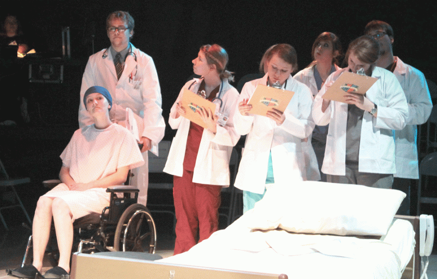 Dr. Harvey Kelekian (Nathan Seaman) and his residents spend a moment with cancer patient Dr. Vivian Bearing (Hope Pederson) in the play “Wit.”