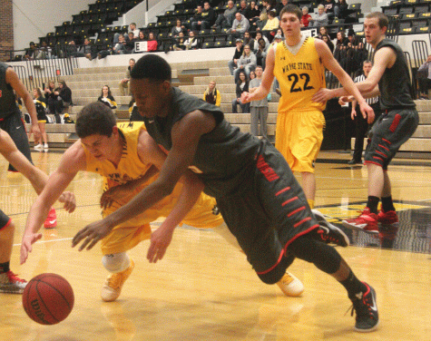 Wayne State’s Austin Ester and Moorhead’s Prescot Williams lunge for the ball at the Feb. 4 basketball game at Minnesota State University. The game would end the Wildcat’s season with a record of 7-31.