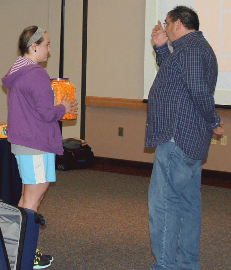 WSC student Bridget Hansen receives her prize of cheeseballs from host Keith Kirkland.