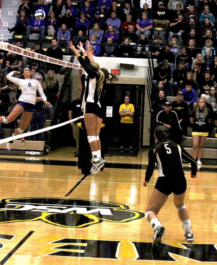 Two WSC volleyball players leap to block an incoming shot from Kearney in last Tuesday’s game.