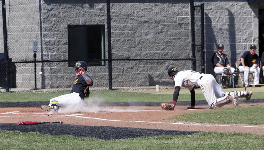 Junior Catcher Bodie Cooper sliding into home base off one of the ten Golden Eagles errors.  