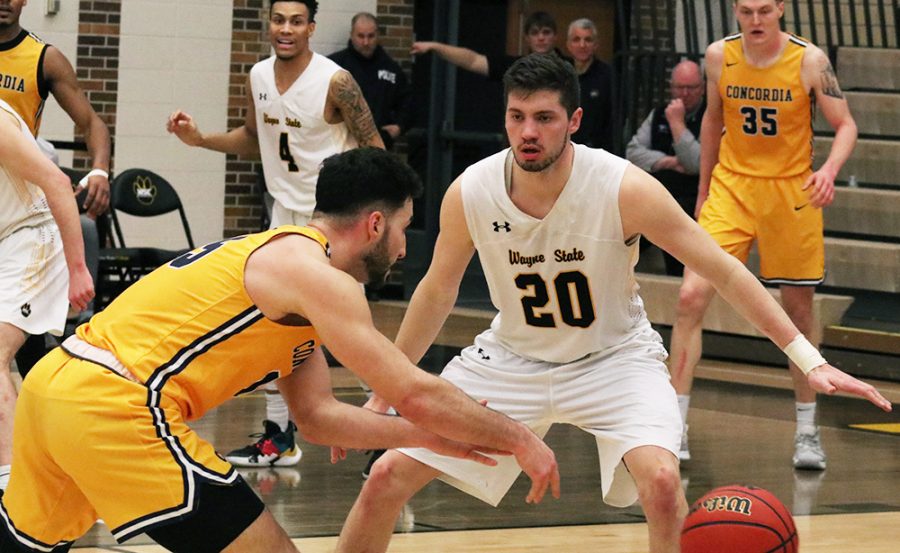 Benjamin Dentlinger keeps an eye on Concordia player while on defense.