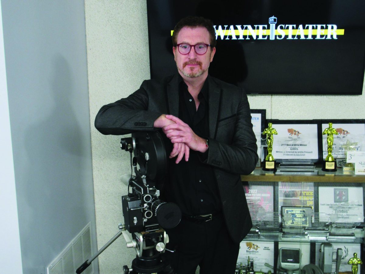 Dr. Michael White poses with his film camera in the Humanities building 
before going to the Majestic Theatre for the premiere of his film.