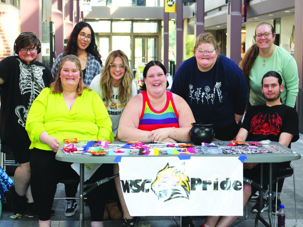 Members of the PRIDE and Its On Us clubs pose for a photo at PRIDE Club's National Coming Out Day Table. Photo by Taylor Sloger.