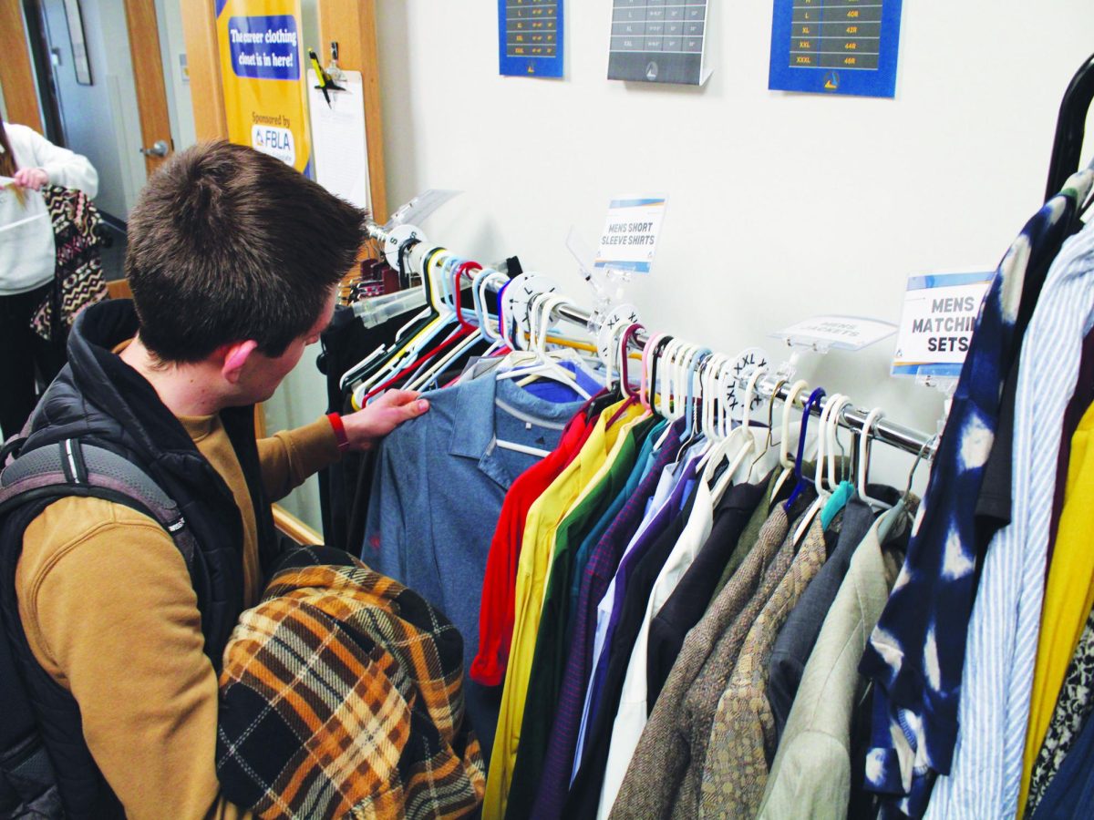 WSC junior Braxton Dalton scans the rack, looking for a shirt that fits his style at the Wildcat Career Clothing Pop-up.