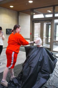 Wayne State College student Kirsten Schmuecker pies Rachel Kunz, a WSC criminal justice professor, at the Pie-A-Professor fundraiser in the Kanter Student Center atrium on Wednesday, April 15.